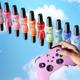 A collection of nail polishes sits on a mirror, facing the sky. A hand holding a controller crosses in front of them.